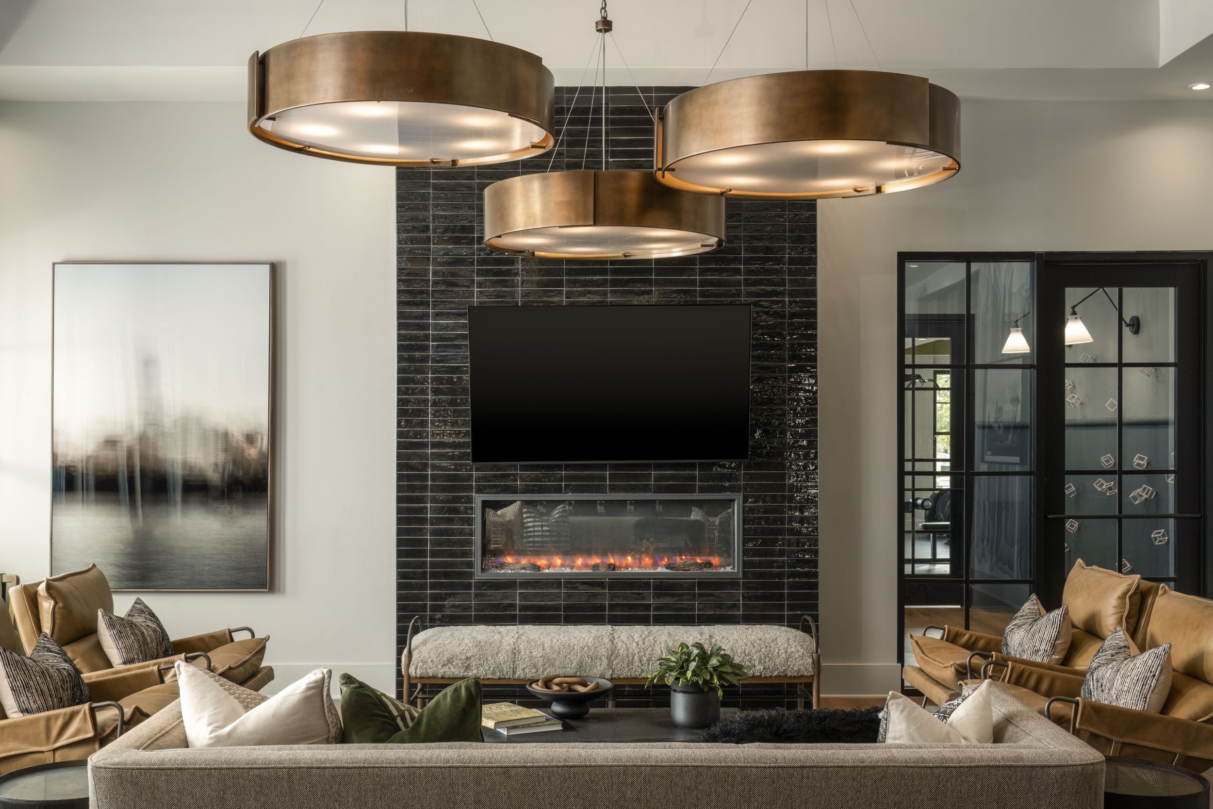 Modern living room with gallery wall, gray sofa, coffee table, and view into dining area and kitchen.