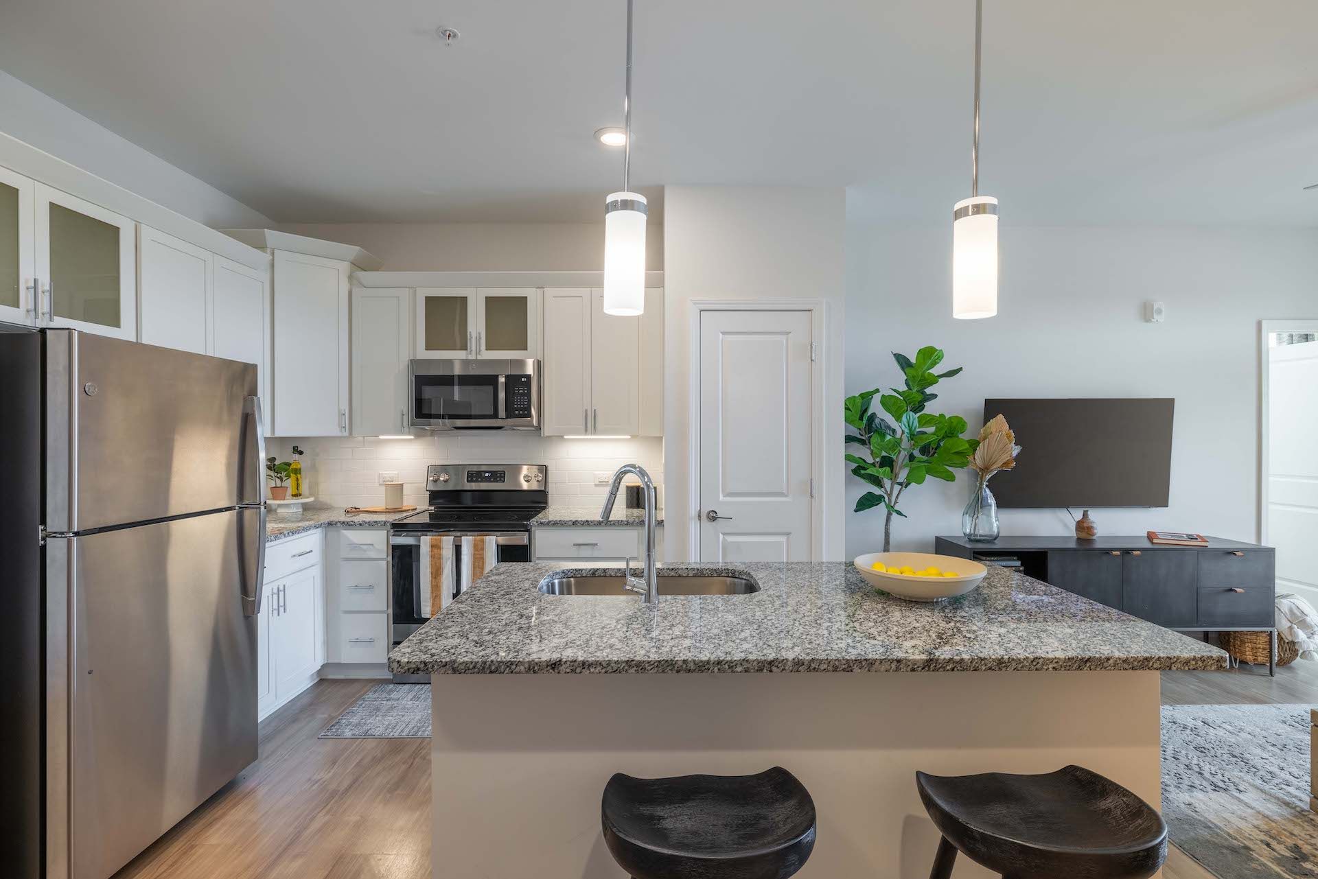 Evolve at the Pines A modern kitchen featuring stainless steel appliances and elegant granite countertops, showcasing a sleek and stylish design.