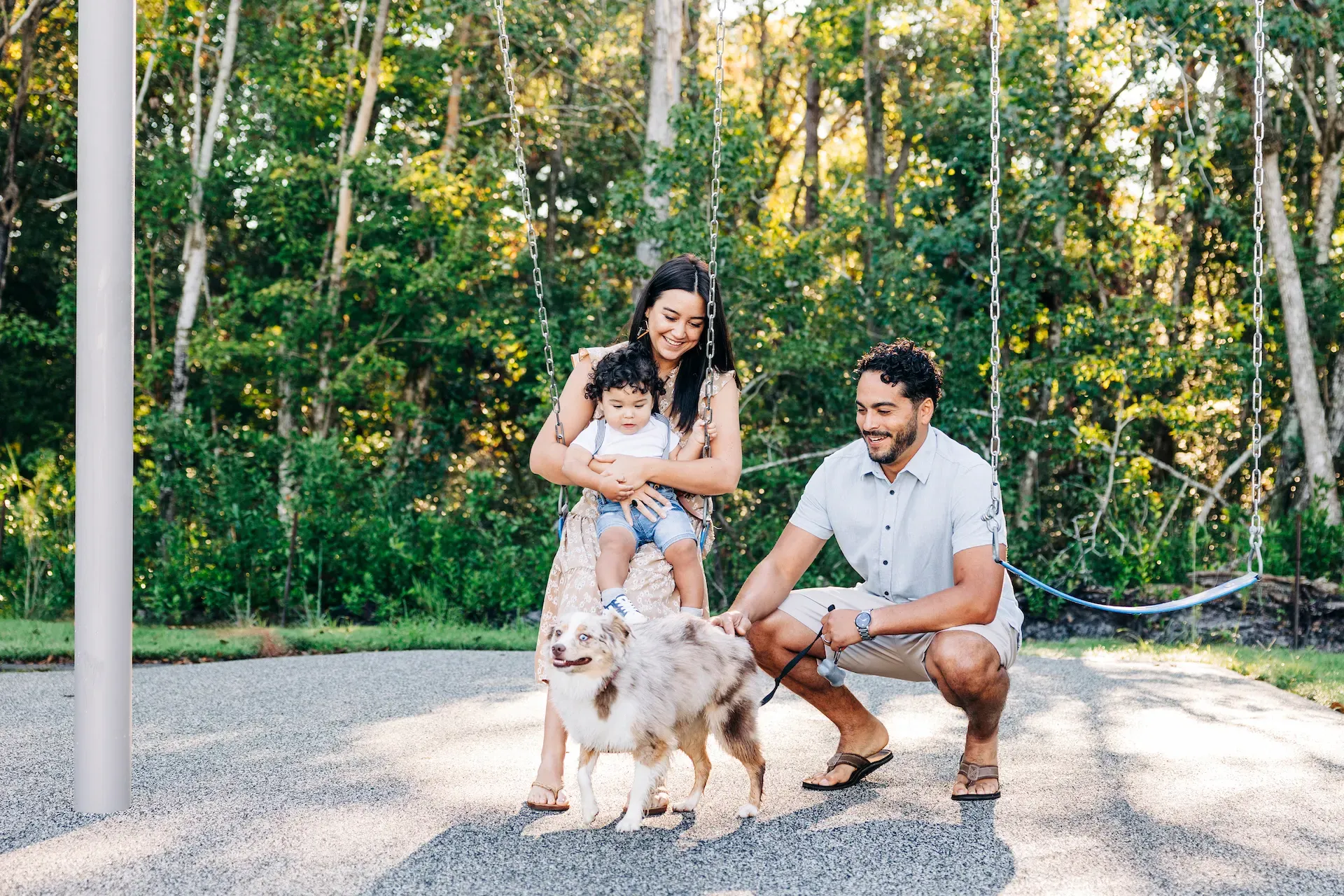 Evolve at the Pines A family enjoying a sunny day in the park with their dog, surrounded by greenery and playful atmosphere.